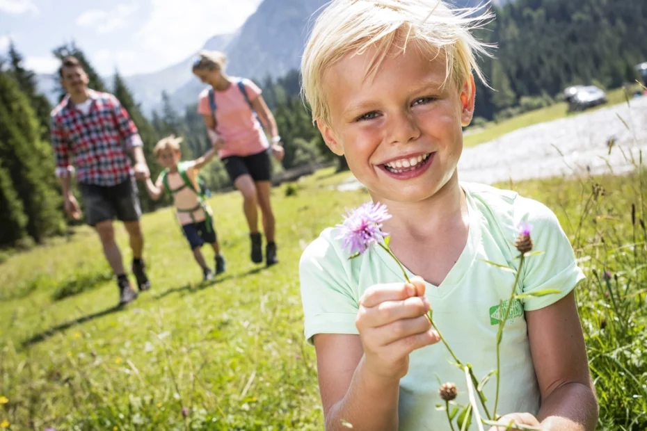Familie mit zwei Kindern wandert über Almen im Familienurlaub in Österreich