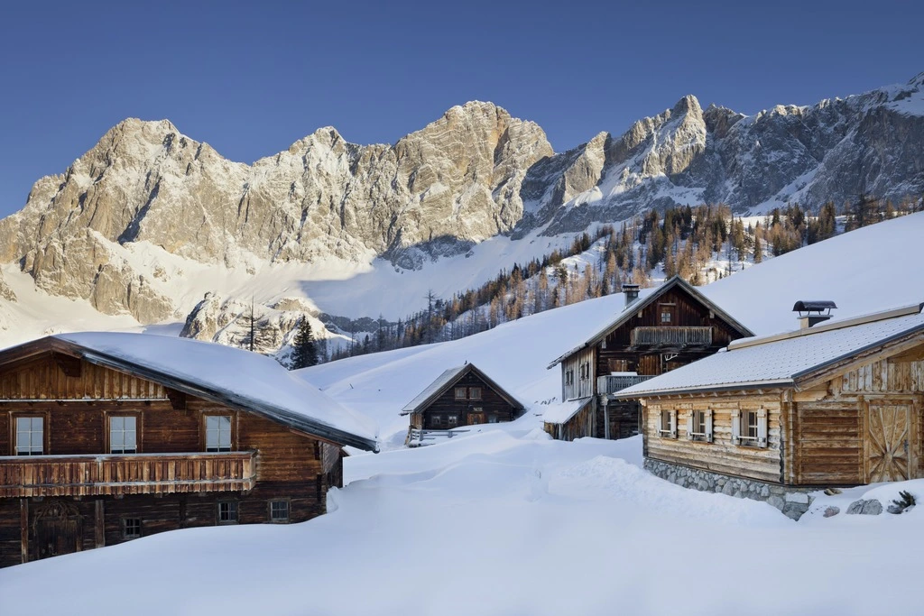 Chaletdorf in Österreich vor atemberaubender Bergkulisse des Dachsteins
